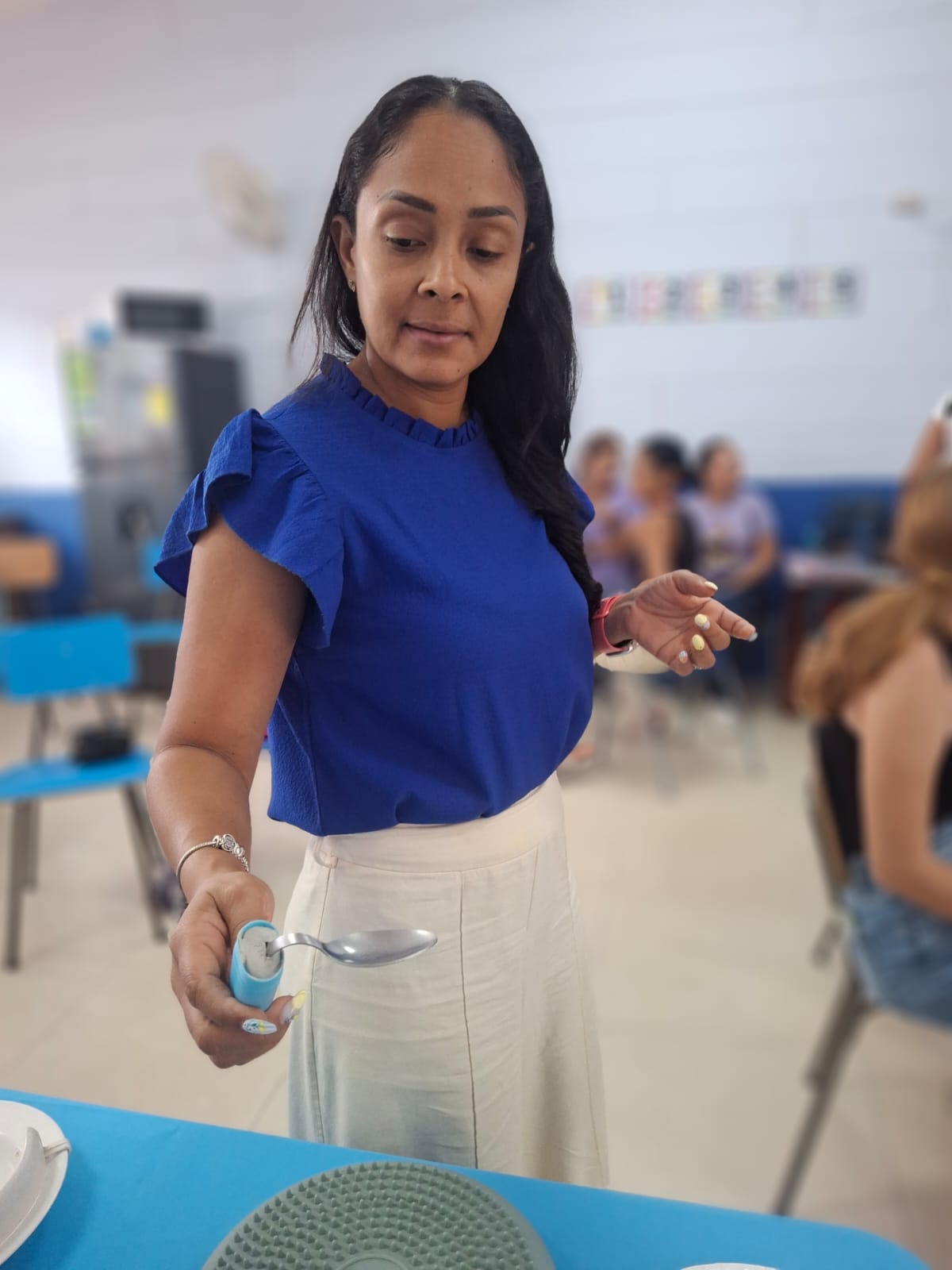 Participante del taller muestra una cuchara adaptada